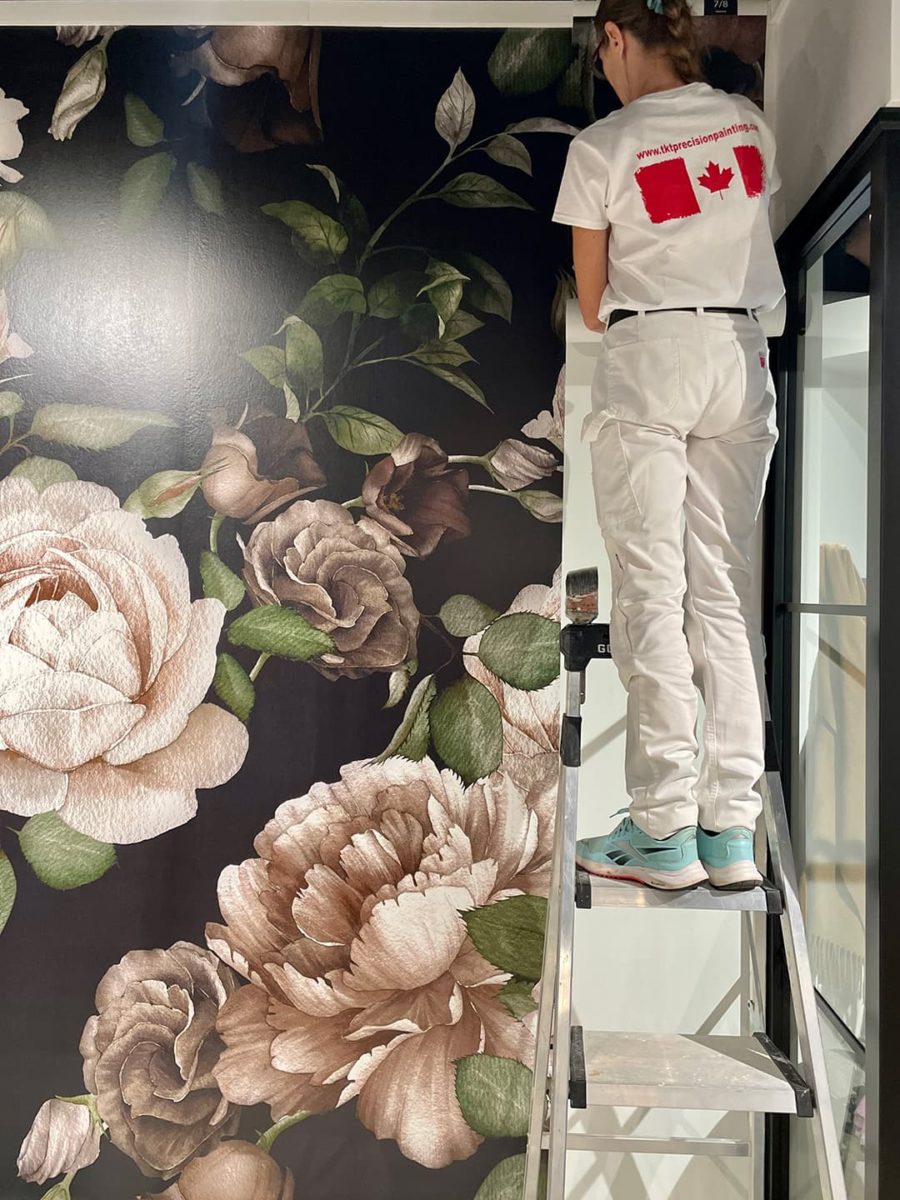 Woman on ladder installing Photowall wall mural in a room