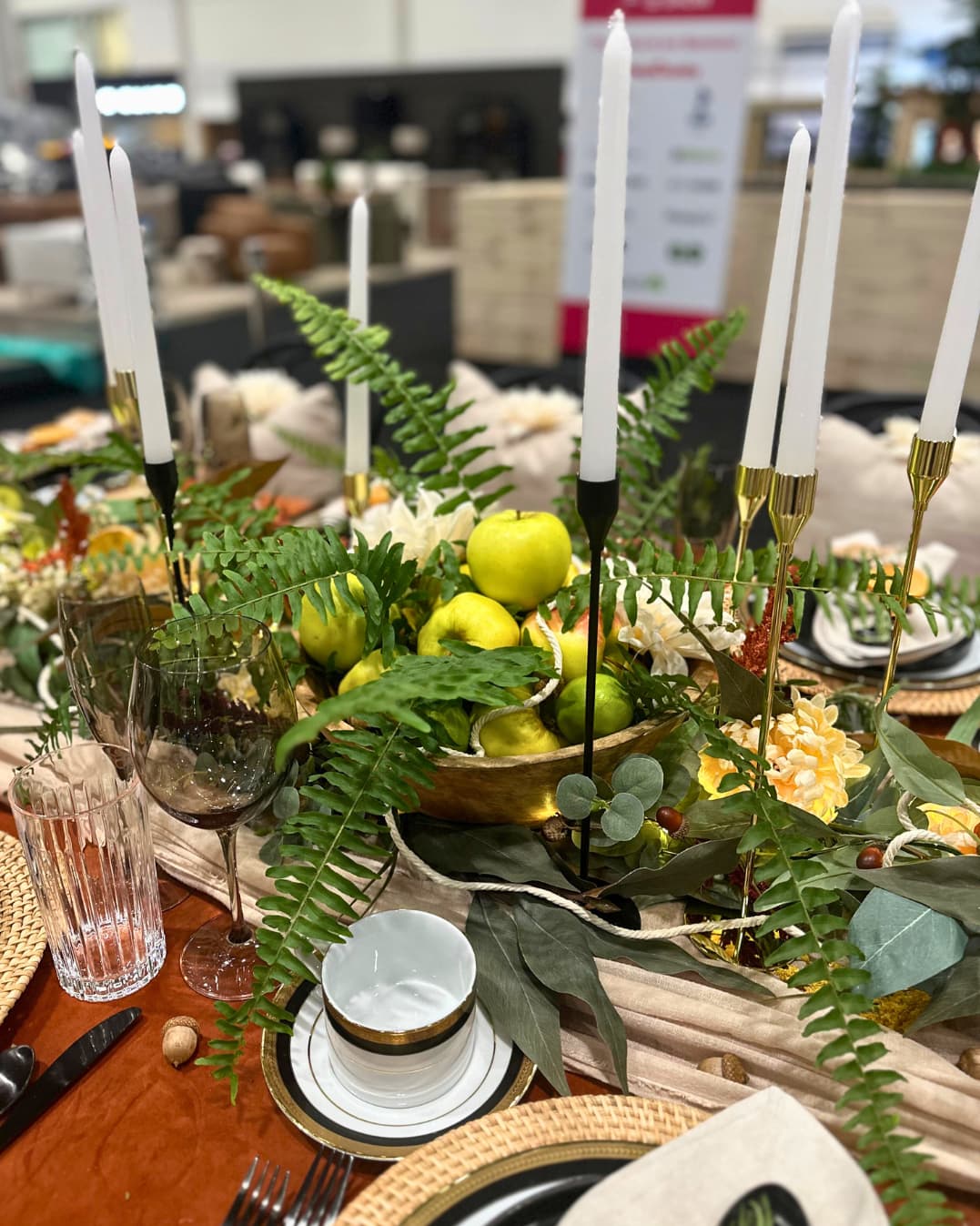 decorative fall table centrepiece with ferns, green apples, candles