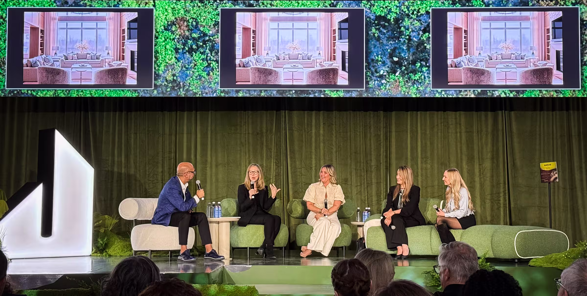 Jane speaking on stage with panel at Living Luxe