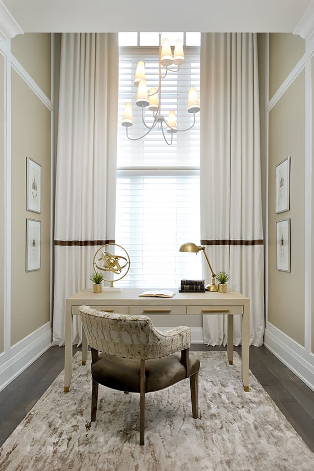 home office desk in front of large window with chandelier above