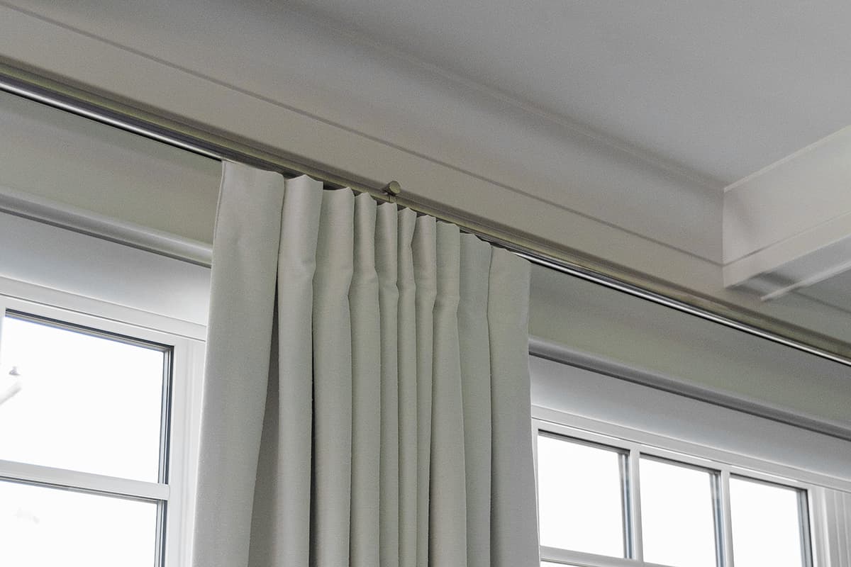 close up of white drapes on a black curtain rod