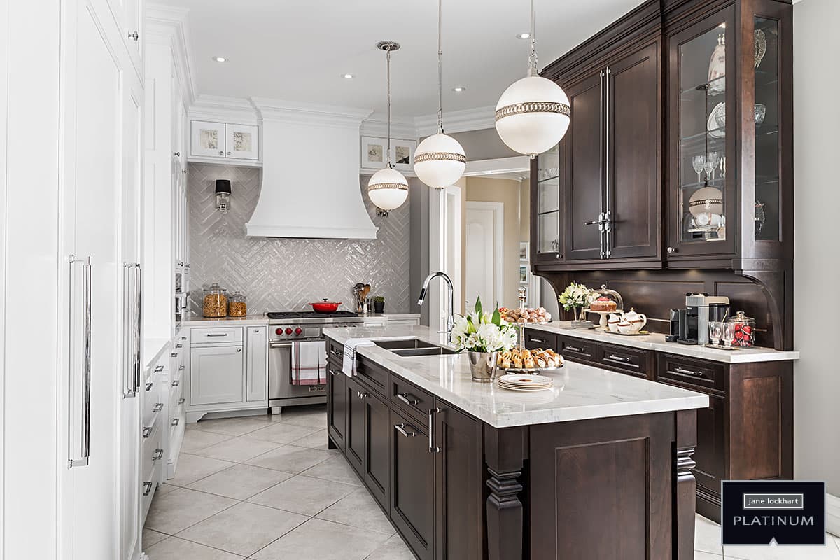 large modern kitchen with island, 3 globe pendant lights, dark wood and white cabinetry Jane Lockhart Design