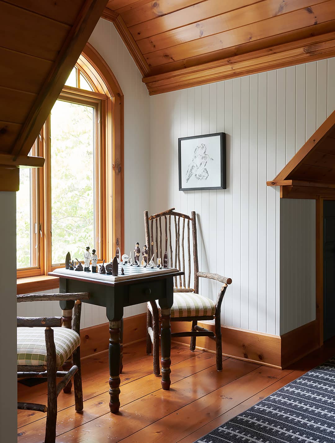 chessboard on table with two chairs and large window