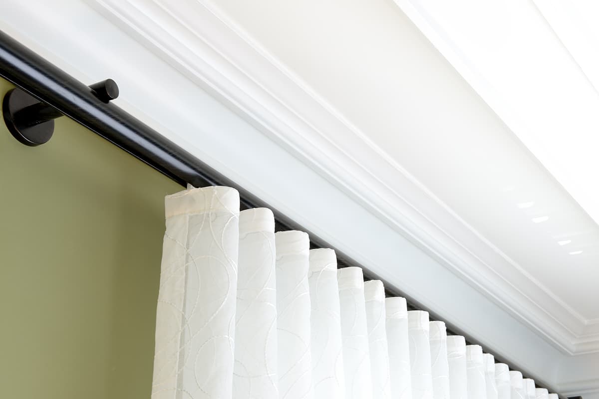 close up of white drapes on a black curtain rod