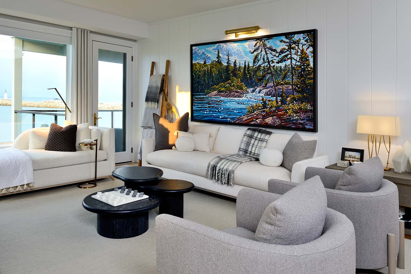 living room with large landscape painting over white sofa