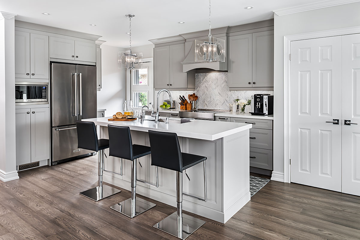 White modern kitchen with island and 3 black bar stools.