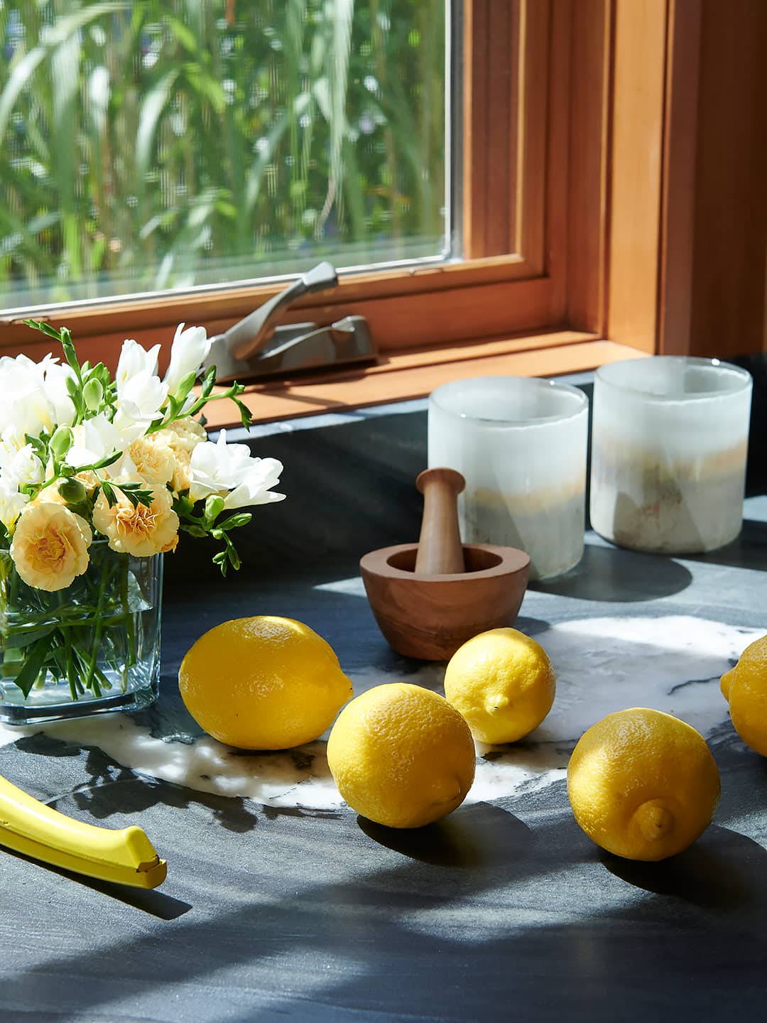 lemons, fresh cut flowers, mortar and pestle