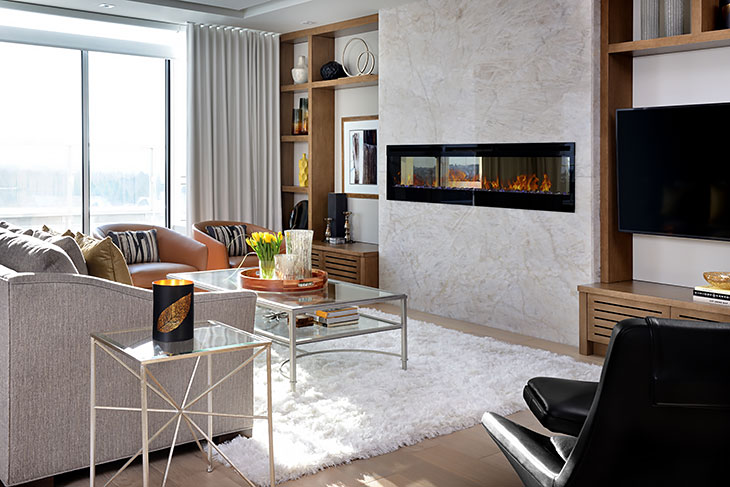 Bright contemporary living room with a modern linear fireplace, built-in shelving, glass coffee table, and plush white rug