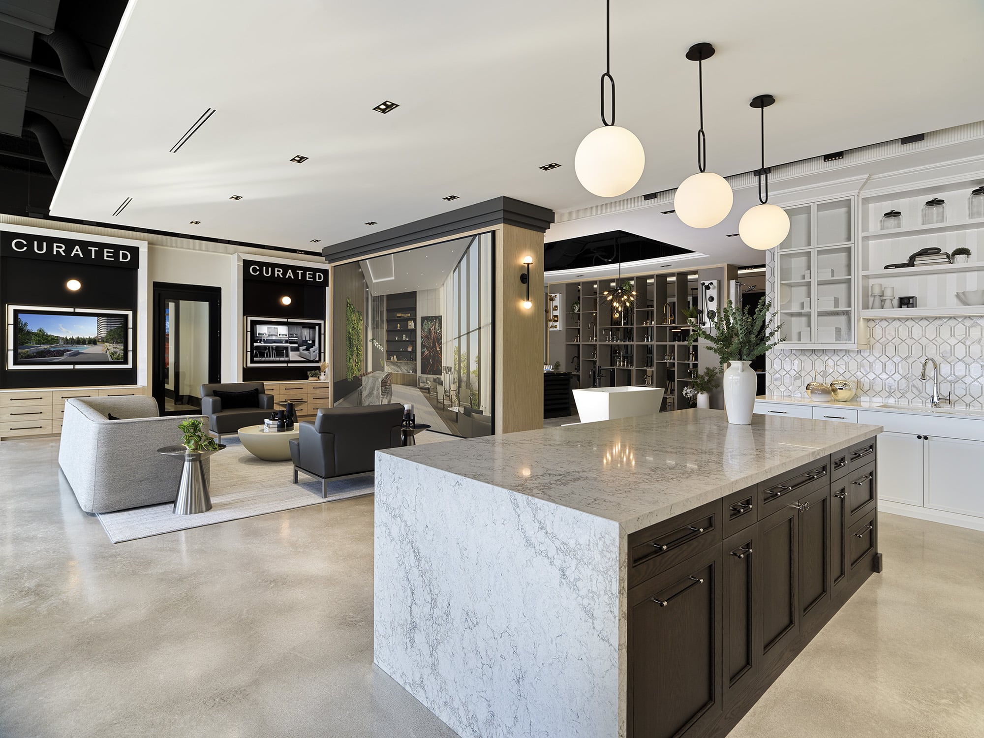 Open-concept kitchen and lounge area at the Primont XC featuring a marble island, curated media walls, and contemporary seating